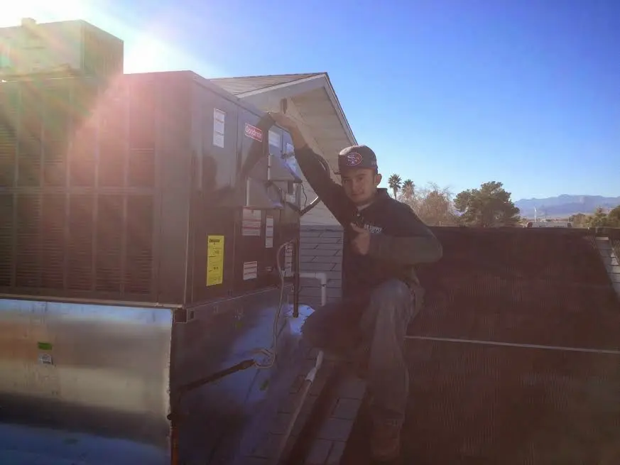 HVAC technician performing AC Tune-Up on a rooftop unit in Tolleson